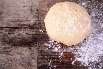 Small balls of fresh homemade dough on floured wooden board