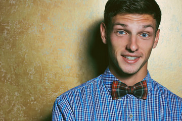 Emotive portrait of smiling handsome young man in blue plaid shi