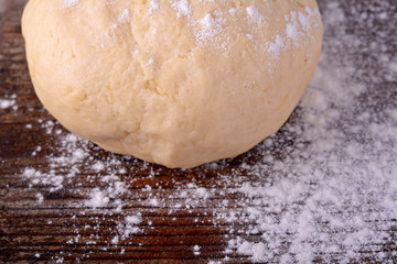 Small balls of fresh homemade dough on floured wooden board