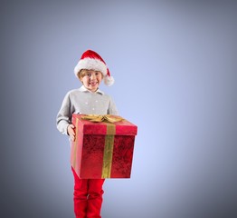 Composite image of festive boy holding gift