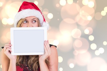 Composite image of festive blonde showing a tablet
