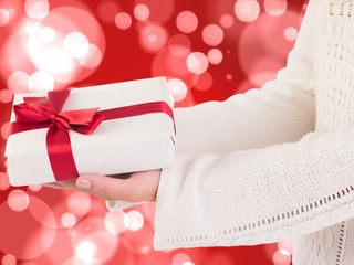 Composite image of woman offering a gift box