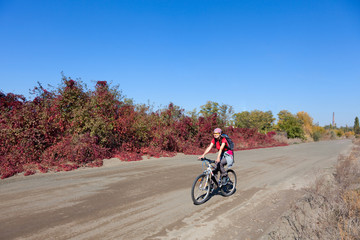 Fototapeta premium Woman riding a mountain bike on a rural road