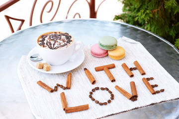 Cup of coffee with cute drawing on table, close up