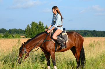 Fototapeta premium The woman on a horse in the field