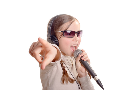 a young girl with headphones singing with a microphone