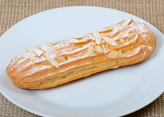 Eclair with a cream on a plate