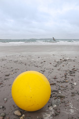 giant yellow buoy on beach