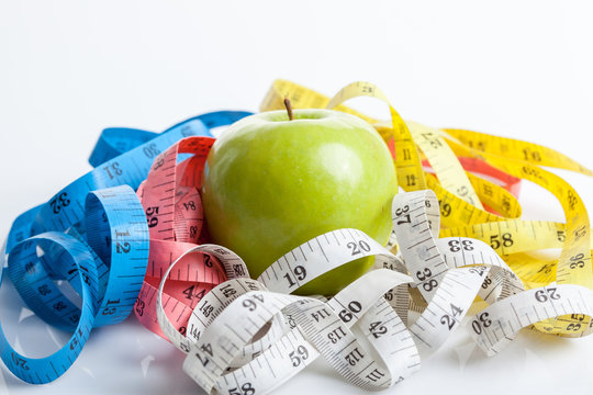 Colorful measuring tapes with green apple
