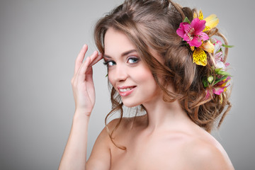 Fototapeta premium Beautiful girl with varicoloured flowers in hairs