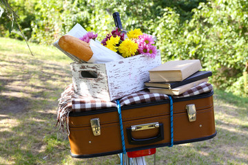 Bicycle and brown suitcase with picnic set