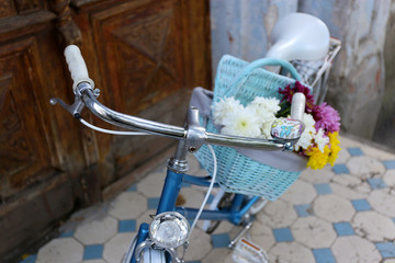 Old bicycle with flowers in metal basket