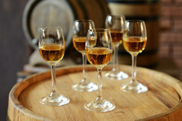 Glasses of wine in cellar with old barrels