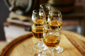 Glasses of wine in cellar with old barrels