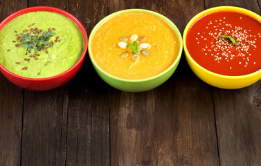Three fresh soups on a wooden table