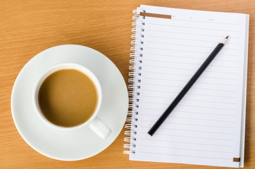 Notebook pencil coffee on the wooden table
