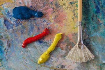 Primary colours on a palette with a fan brush