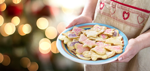 woman serving homemade christmas cookies - obrazy, fototapety, plakaty