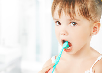 happy little girl brushing her teeth