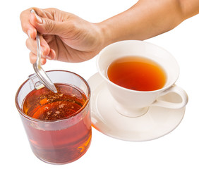 Female hand mixing honey with tea over white background