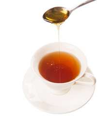 Mixing honey with tea with a tea spoon.