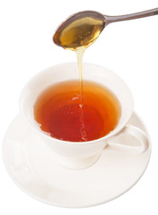 Mixing honey with tea with a tea spoon.