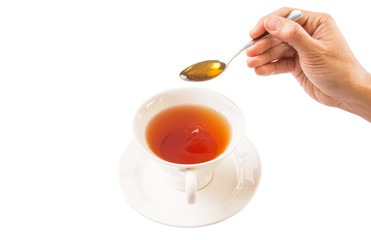 Female hand mixing honey with tea over white background