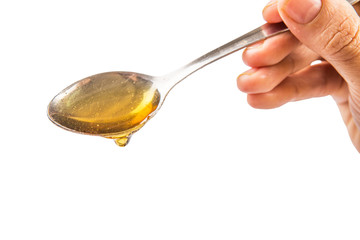 Female hand holding a spoon of honey over white background
