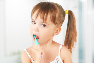 happy little girl brushing her teeth