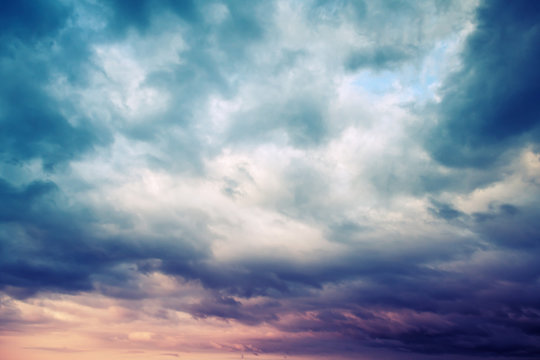 Dark blue stormy cloudy sky natural photo background, toned © evannovostro