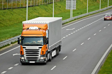 Orange truck on highway chased by small car