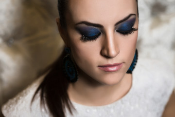 Portrait of a woman with blue smokey eyes make-up and bijou