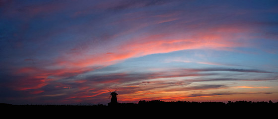 panorama of the sky with red clouds at sunset with windmill