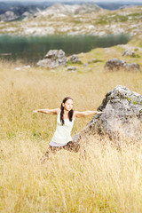 Fototapeta na wymiar Yogaposen im hohen Gras vor einem Bergsee in den Alpen