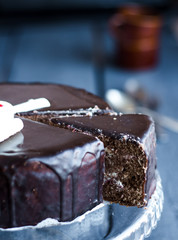 cut a chocolate cake with butter cream and cherries, holiday