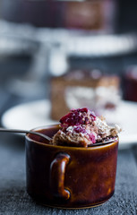 spoon with chocolate cake with butter cream and cherries, cup