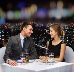 smiling couple eating main course at restaurant