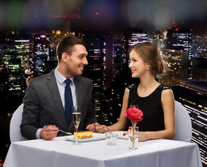 smiling couple eating dessert at restaurant