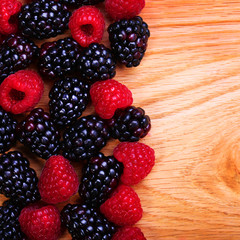 Raspberries and Blackberry on Wooden Background