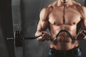 Fototapeta na wymiar Close up of young muscular man lifting weights