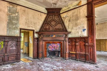 Tuinposter Massive fireplace in an abandoned mansion © tobago77
