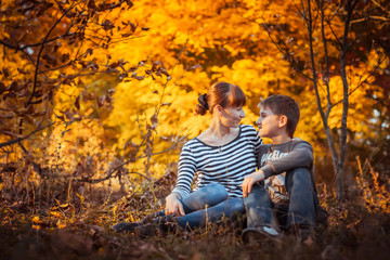 Beautiful mother with son in autumn park