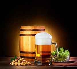 Beer barrel with beer glass on a wooden table. The dark backgrou