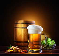 Beer barrel with beer glass on a wooden table. The dark backgrou