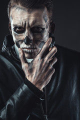 Portrait of pensive man with make-up  skull