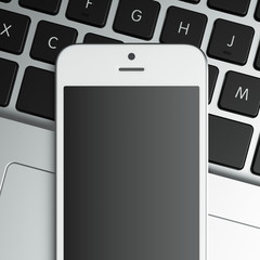 blank smart phone on the laptop