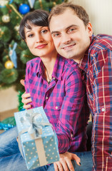 Happy couple with gift boxes under the christmas tree