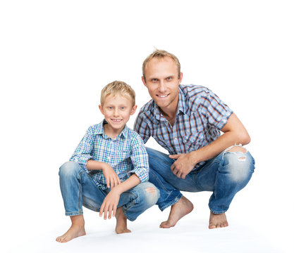 Father with son dressed in jeans and plaid shirts on the white