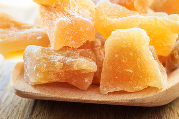 Closeup candied ginger on wooden spoon