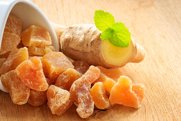 Closeup root and candied ginger on wooden table
